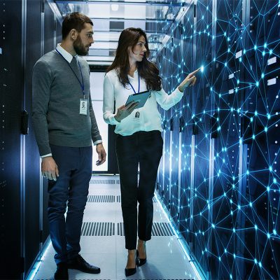 Female and Male IT Engineers Discussing Technical Details in a Working Data Center/ Server Room with Internet Connection Visualization.
