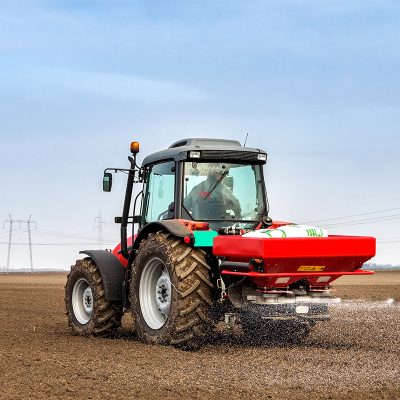 Farmer fertilizing arable land with nitrogen, phosphorus, potassium fertilizer